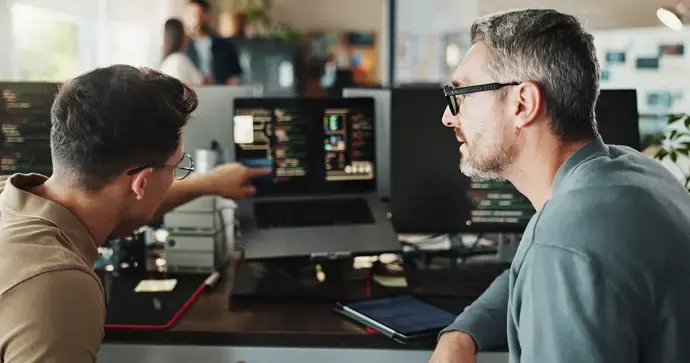 Technical instructors reviewing data on a computer during a professional training session