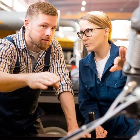 Apprentice in training supported by a professional in a technical environment