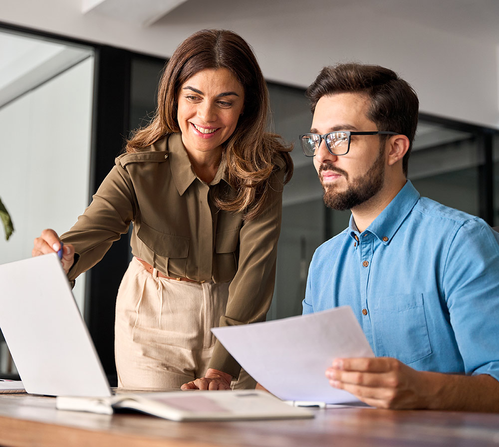 Two colleagues reviewing documents in a professional environment illustrating gender equality and workplace fairness